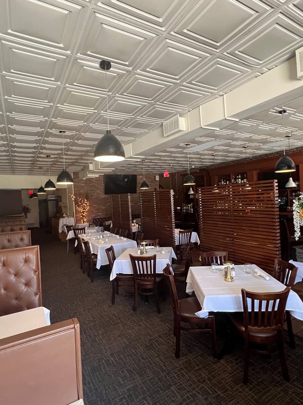 Booths and tables set with white tablecloths at App’s Restaurant